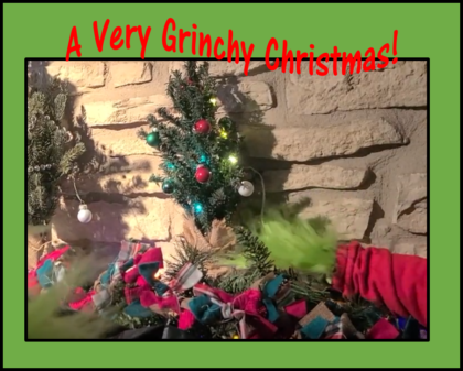 Photograph of a Grinch hand in front of a Christmas tree entitled, A Very Grinchy Christmas.